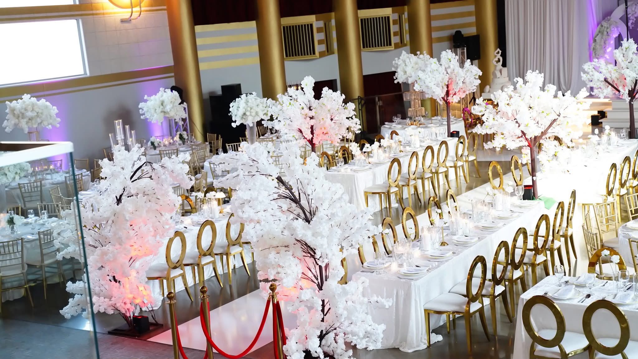 White floral tablescape with gold chairs and candlelight