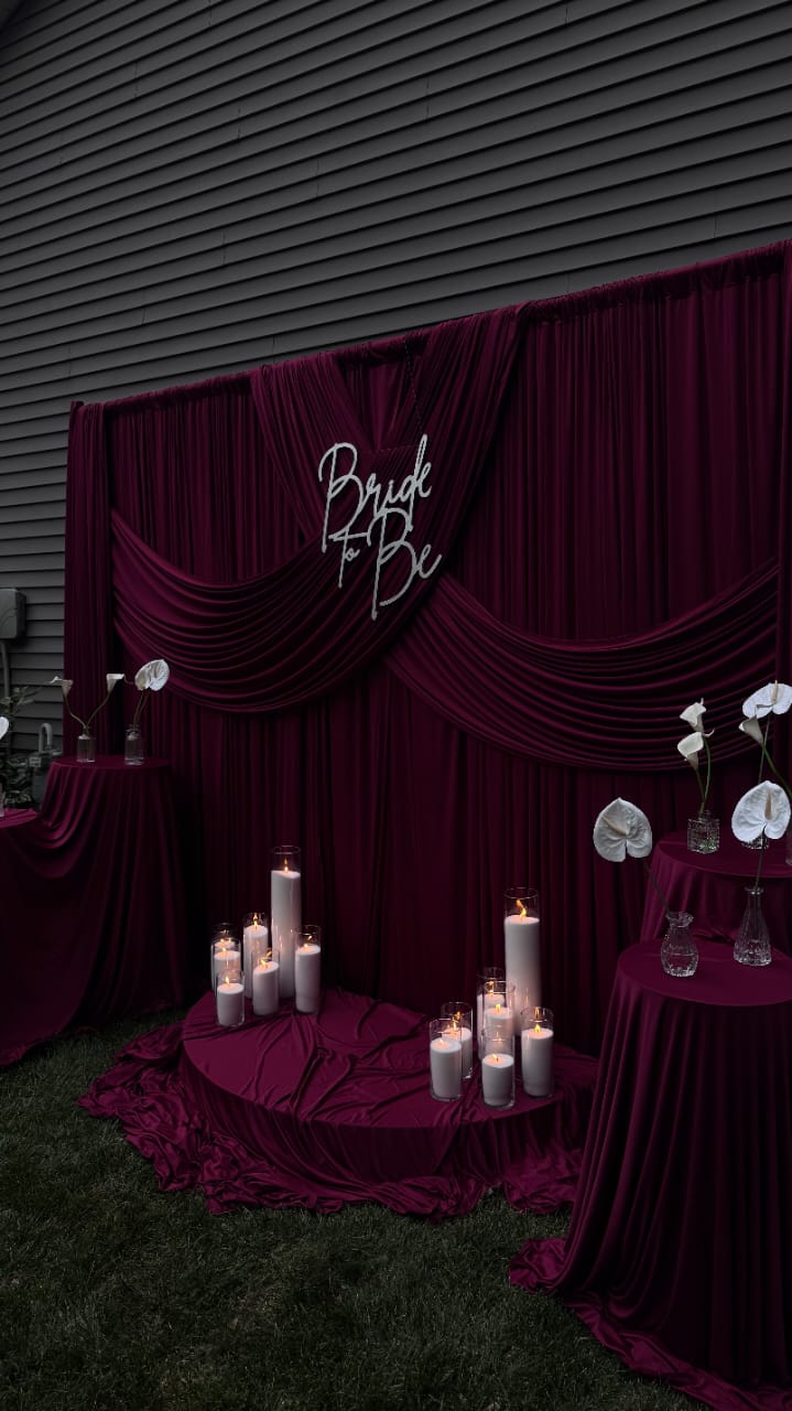Bridal event styling with burgundy florals and candlelight