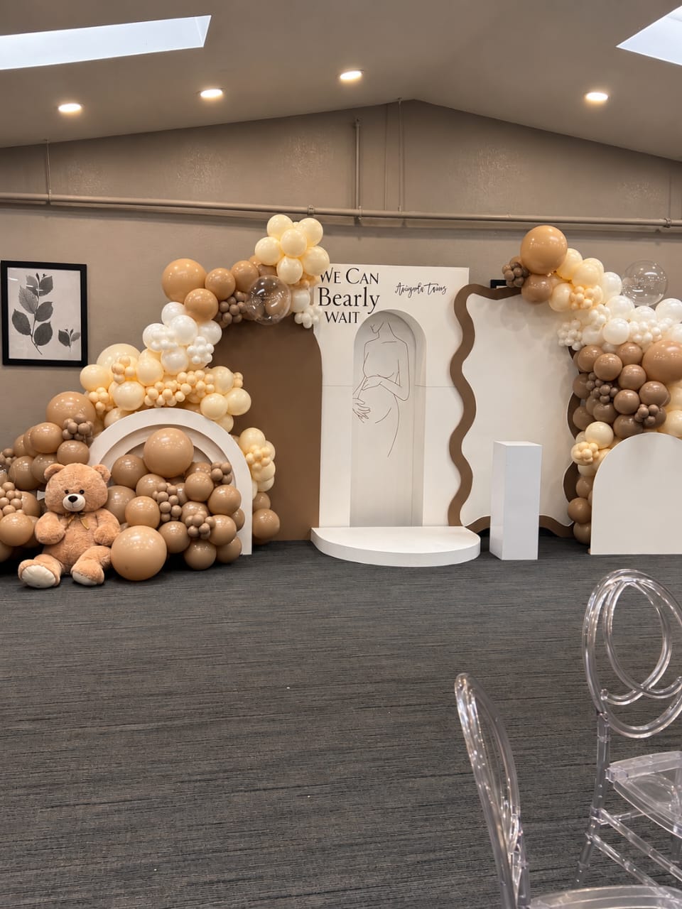 Warm neutral balloon and backdrop installation for a baby shower